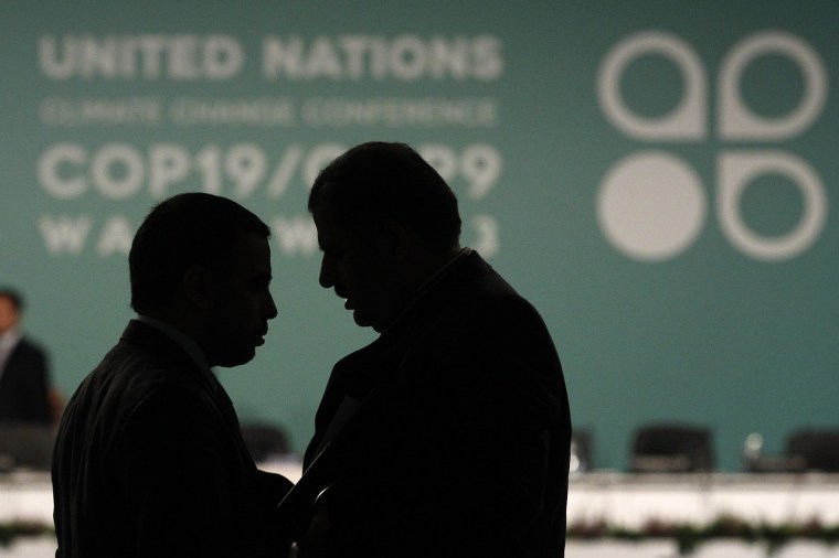 Delegates talk during a break in a plenary session at the 19th conference of the United Nations Framework Convention on Climate Change (COP19) in Warsaw. The divide is deep between rich and poor countries over who should pay for climate change aid.