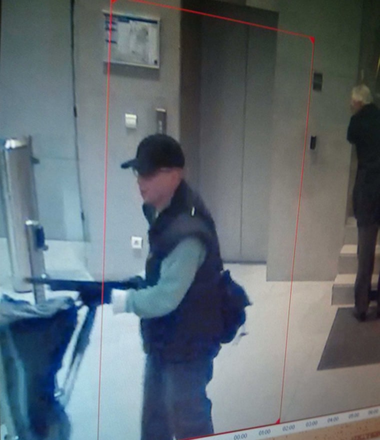 A man points a shotgun on Nov. 15 in Paris in this image from a security camera released by the Paris police.