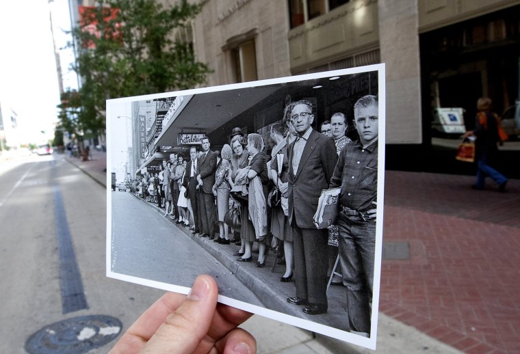 People line Travis Street near Rusk Street to see President John F Kennedy's motorcade during a visit to Houston, Nov. 21, 1963.