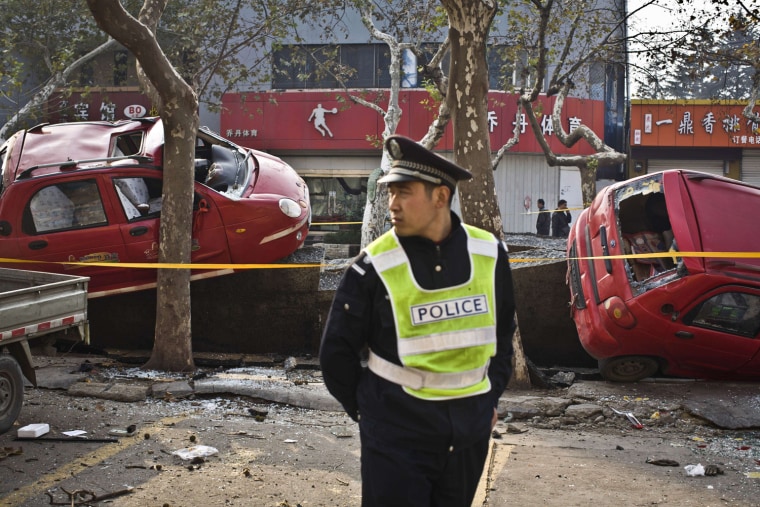 Damaged vehicles lie near the blast site after the explosion.