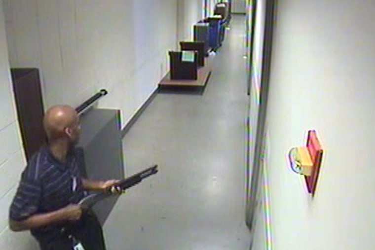 Aaron Alexis moves through the hallways of Building 197 at the Washington Navy Yard carrying a Remington 870 shotgun.