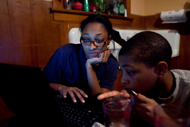 Mesha Exum takes a break from doing her homework to let her son Adonis Exum, 11, use her laptop Nov. 12, 2013, in Chicago, Ill. (Photo by Armando L. Sanchez)