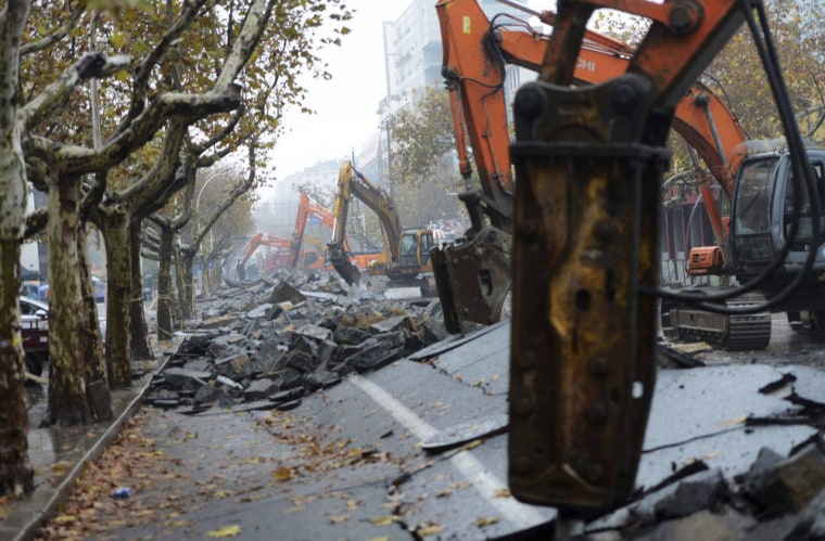 Heavy machinery are seen at work at a damaged street after an explosion at a Sinopec Corp oil pipeline in Huangdao, Qingdao, Shandong Province.