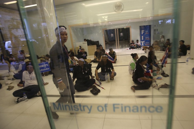 Anti-government protesters sit inside the Finance Ministry building in Bangkok, Thailand, Monday.