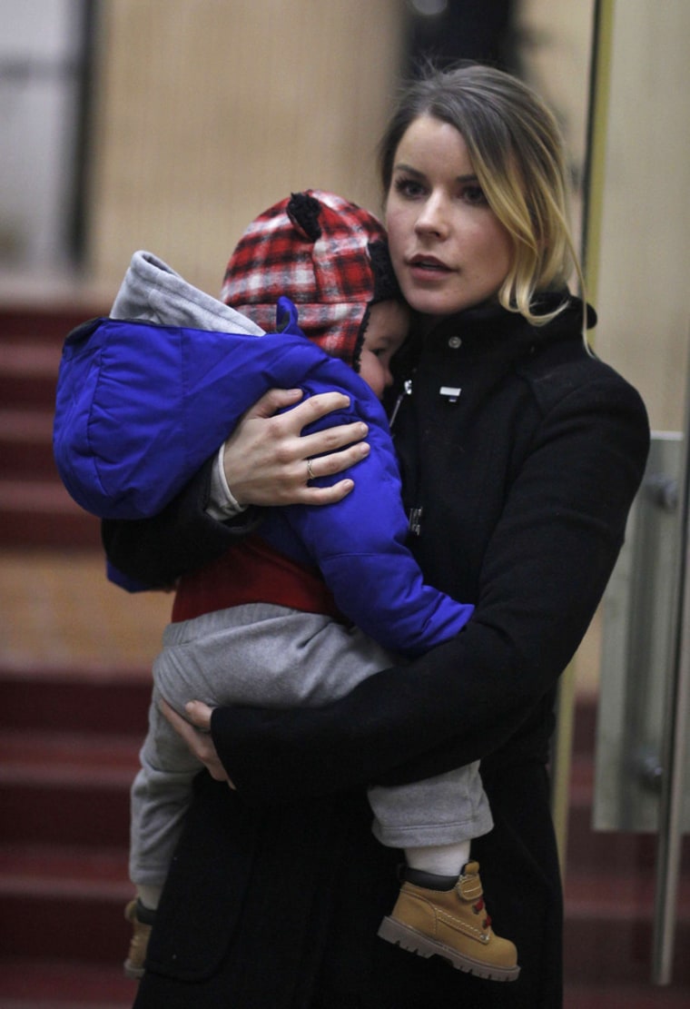 Sara McKenna carries her son while they leave Manhattan's Family Court in New York, November 25, 2013.