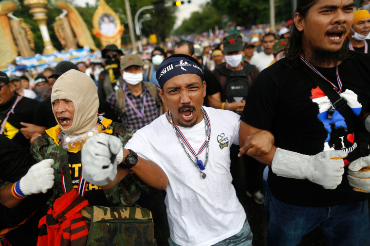 Anti-government protesters shout as they get ready to attack a police barricade near the Government house in Bangkok, Monday.