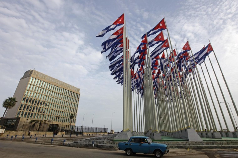 A car drives past the building of the the U.S. diplomatic mission in Cuba, The U.S. Interests Section, (USINT), in Havana. Its Washington counterpart has been shuttered by a banking problem.