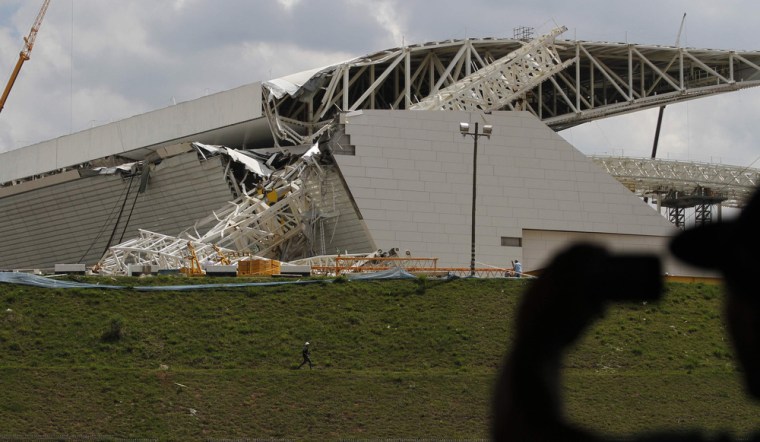 A man takes a picture of a crane that collapsed on the site of the Arena Sao Paulo stadium, which will host the opening soccer match of the 2014 World Cup, in Sao Paulo on Wednesday.
