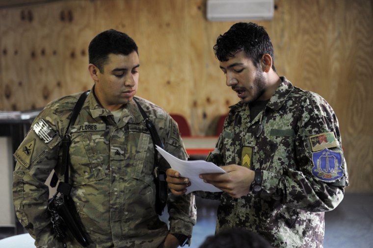 A member of the US Army (L) speaks with an Afghan National Army (ANA) soldier during a training session at the Narizah base in Narizah, Khost Province on August 13, 2012.