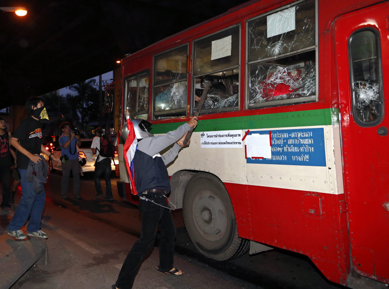Thai anti-government protesters attack a public bus which Red Shirt pro-government supporters transport them toward a support government rally outside Rajamangala National Stadium in Bangkok, Thailand, 30 November 2013. Bangkok has been rocked by protests since 01 November 2013, when the ruling coalition attempted to push through an amnesty that would have pardoned Thaksin and thousands of other politically related cases during 2004-13.