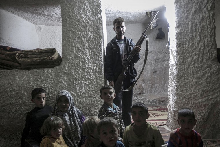 A displaced Syrian family poses for photo inside a cave near Kafer Rouma, on Sept. 26.
