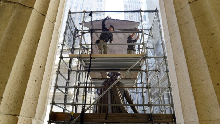 Workers secure scaffolding around a statue of George Washington on the steps of Federal Hall in New York City as restoration work has been halted because of the federal government shutdown on Oct. 1.