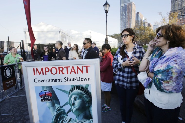 Tourists who had hoped to visit the Statue of Liberty stand near the dock used by Liberty Island ferries on Oct. 1, in New York City.