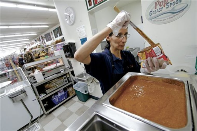 In this Sept. 27, 2013 photo, Loraine Chavez, of Santa Fe, prepares a Frito Pie for a costumer at the Five & Dime in Santa Fe, N.M. The tourist attrac...