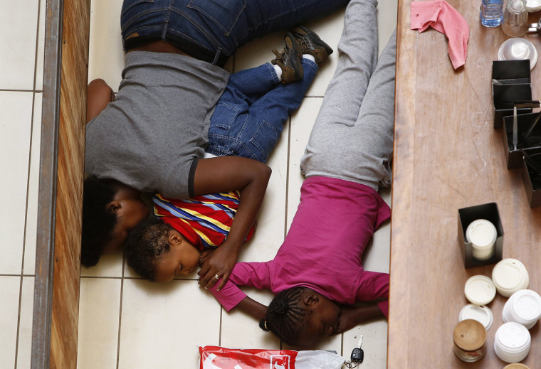 A mother and her children hide from gunmen at Westgate Mall in Nairobi on Sept. 21.