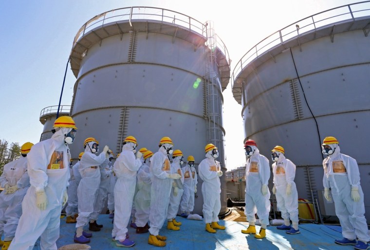 Japanese Prime Minister Shinzo Abe (third from right) is briefed about tanks containing radioactive water on a tour of the Fukushima Daiichi nuclear power plant on Sept. 19, 2013.