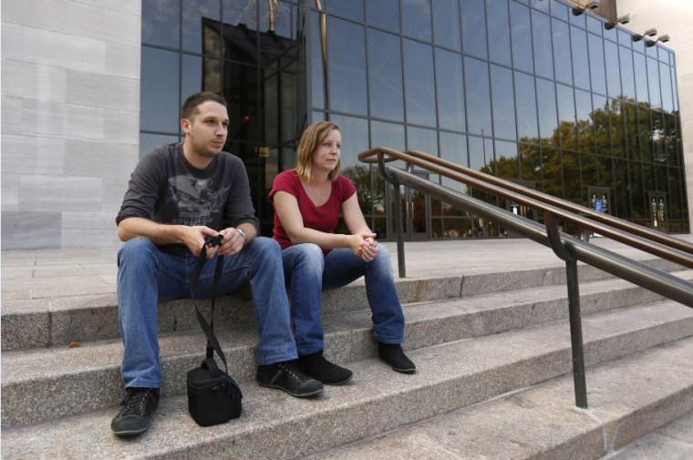 Tourists from France sit outside the closed Smithsonian Air and Space Museum in Washington