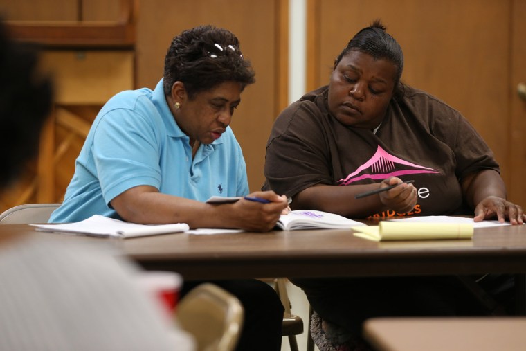 Sara Moye works with Clara Dancer as they complete an exercise about building resources during their Bridges Out of Poverty class on Aug. 13 at the Episcopal Church of the Resurrection in Starkville.