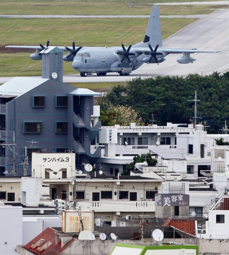 A military transport plane moves to the runway at Marine Corps Air Station Futenma adjacent to the residential area in Ginowan, Okinawa, Japan, on Dec. 17, 2009. When the air station was built in the closing days of World War II, it was surrounded by sugarcane fields and the smoldering battlegrounds of Okinawa.
