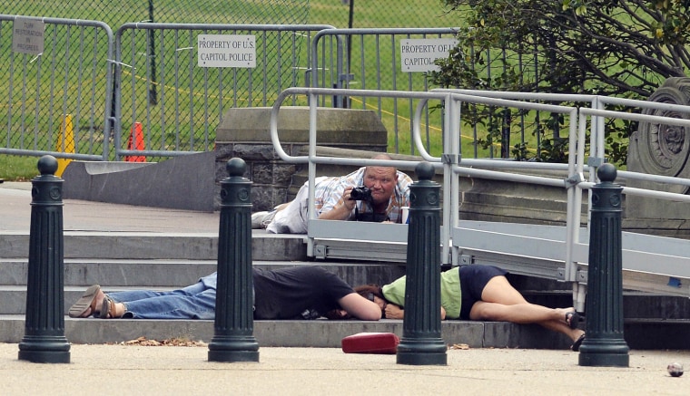 People take cover as gun shots were being heard at the US Capitol in Washington, DC, on October 3, 2013. The US Capitol was placed on security lockdow...