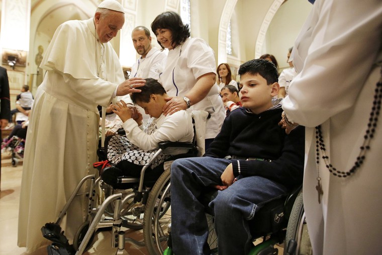 Pope Francis blesses a child during his visit at the Serafico Institute Friday in Assisi.