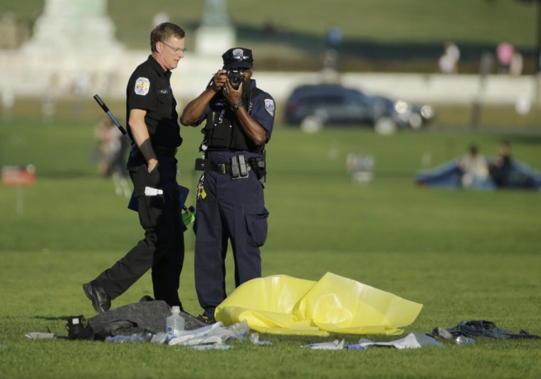 Police investigate the scene where a man apparently set himself on fire Friday on the National Mall in Washington, D.C.