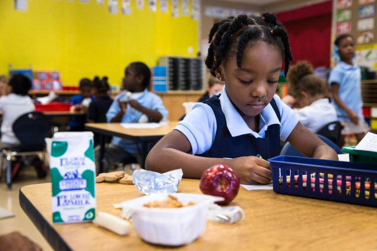 Jamie Norman, 5, starts her schoolwork as she and her classmates at Enrico Fermi School No. 17 finish eating their breakfast, Thursday, Oct. 3, in Rochester, N.Y.