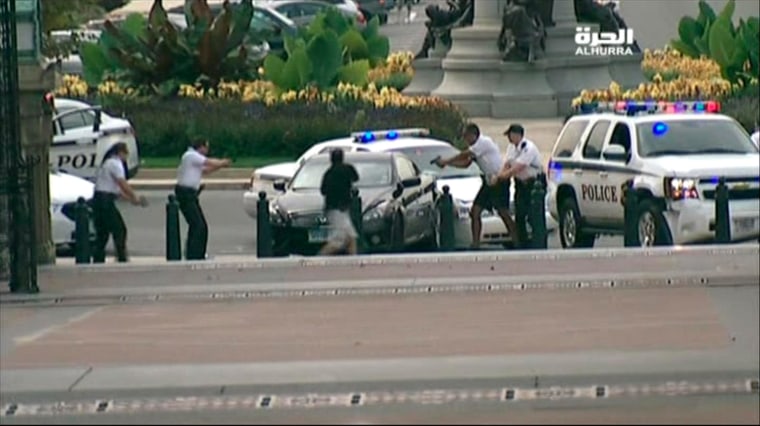 U.S.Capitol Police surround a car driven by Miriam Carey at the corner of Pennsylvania Avenue and 1st Street NW Thursday in this framegrab from Alhurra TV video.