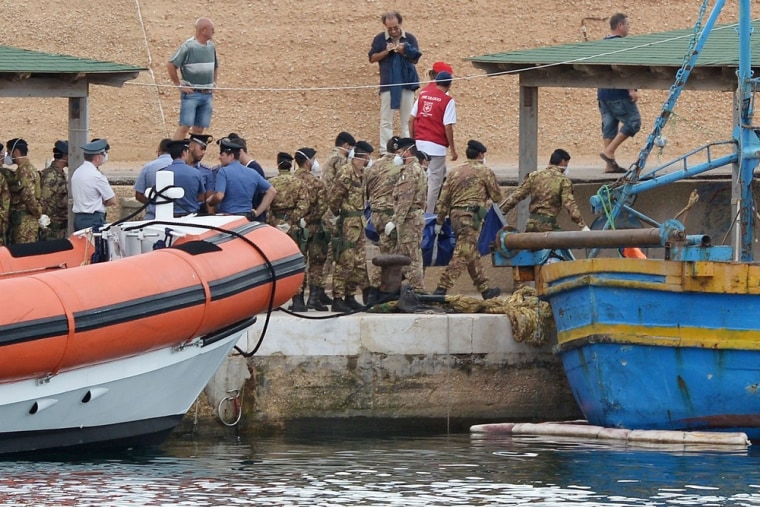 Italian soldiers carry the body of a victim from the ship of immigrants that sank on Thursday.