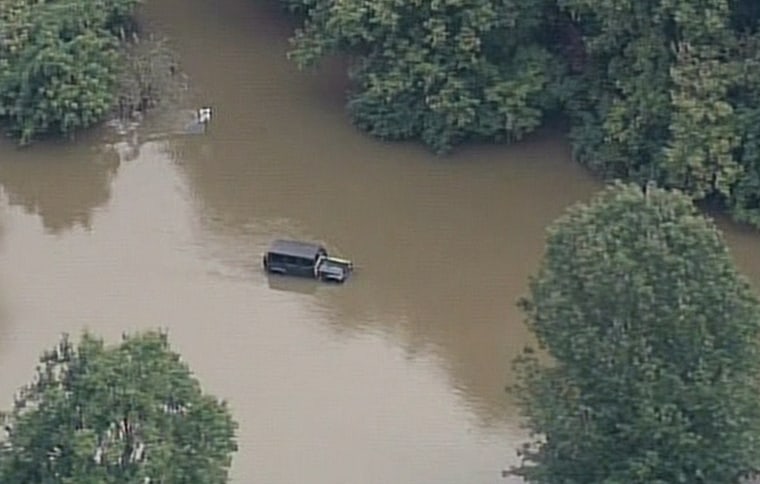 A car sits in floodwaters in Louisville, Ky.
