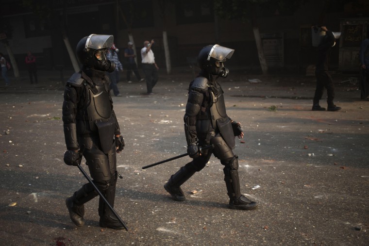 Egyptian riot police move into position during clashes with supporters of ousted President Mohammed Morsi, in Cairo, Egypt, Sunday, Oct. 6, 2013.