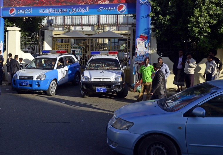 Police vehicles block the entrance of a supermarket following a shooting in Sana'a, Yemen, on Oct. 6.