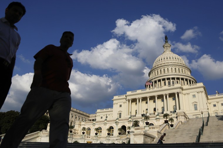 Tourists walk past the U.S. Capitol Dome in Washington October 6, 2013.