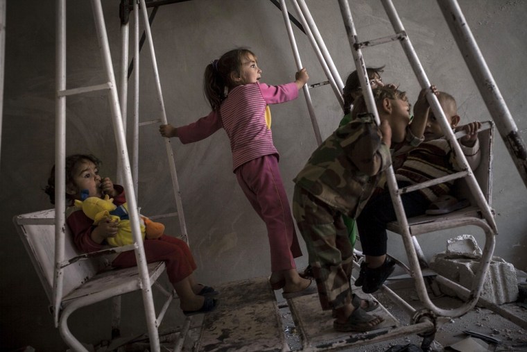 Mohammed Kale's grandchildren play on a swing inside the house.