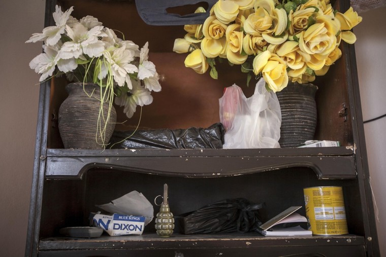A hand grenade sits among flowers at the entrance to the family home.