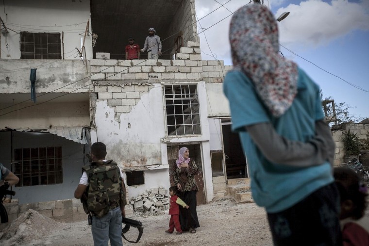 A woman, center, sees off her husband Ahmed, second left, as he leaves for the front line.