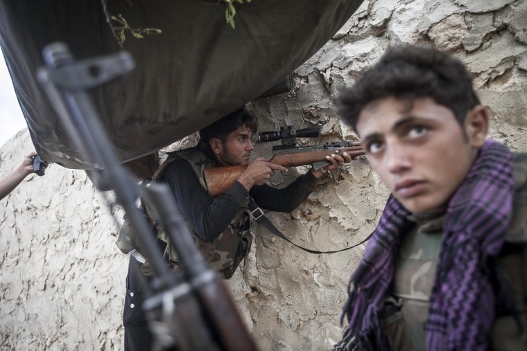 Opposition fighters mount guard at the front line on the outskirts of Kfar Lata.