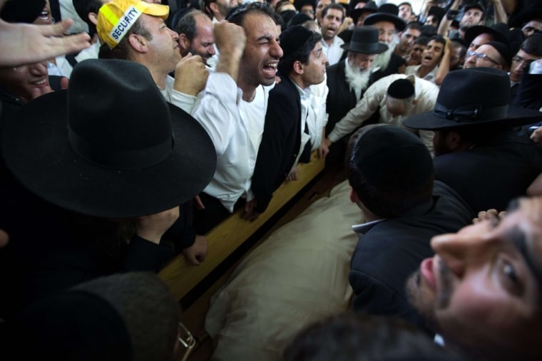 Ultra-orthodox Jewish mourners grieve around the body of their Rabbi Ovadia Yosef during his funeral in Jerusalem on Monday.