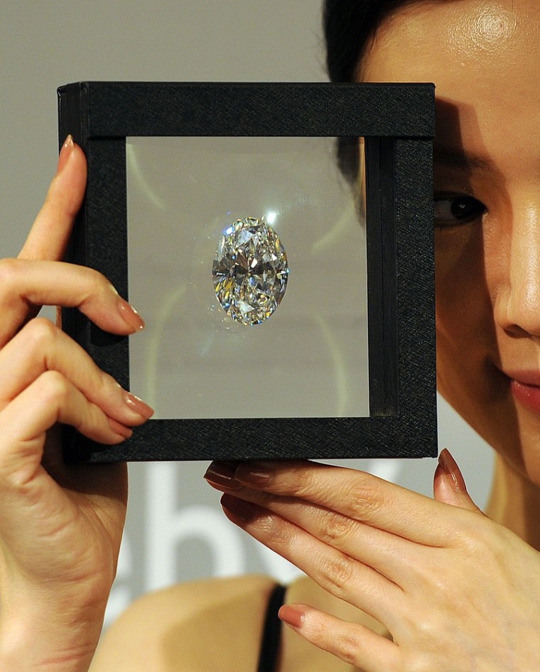 In this picture taken on September 19, 2013 a model holds a flawless oval diamond during a media preview at Sotheby's auction house in Hong Kong. The ...