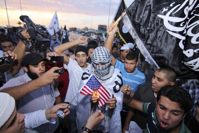 Dozens of supporters of the militant group, Ansar al-Shariah, burn an American flag and shout anti-American slogans denouncing the U.S. violation of Libya's sovereignty in the abduction of Abu Anas al-Libi, in the center of Benghazi, Libya, Monday.