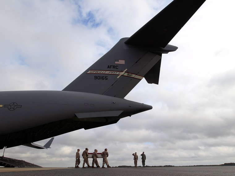 A Marine carry team carries the transfer case containing the remains of Marine Lance Cpl. Jeremiah M. Collins Jr. of Milwaukee, upon arrival at Dover ...