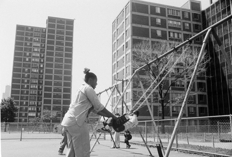 A mother and child, residents of the Cabrini-Green public housing project in Chicago, play in a playground adjoining the project, May 28, 1981.