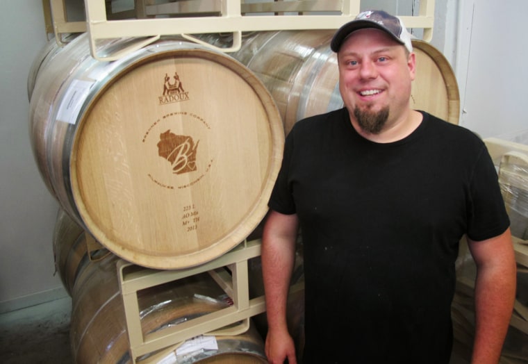 In this Oct. 3, 2013 photo, Mike Brenner, owner of Brenner Brewing in Milwaukee, stands in front of an empty beer barrel. The federal government shutd...