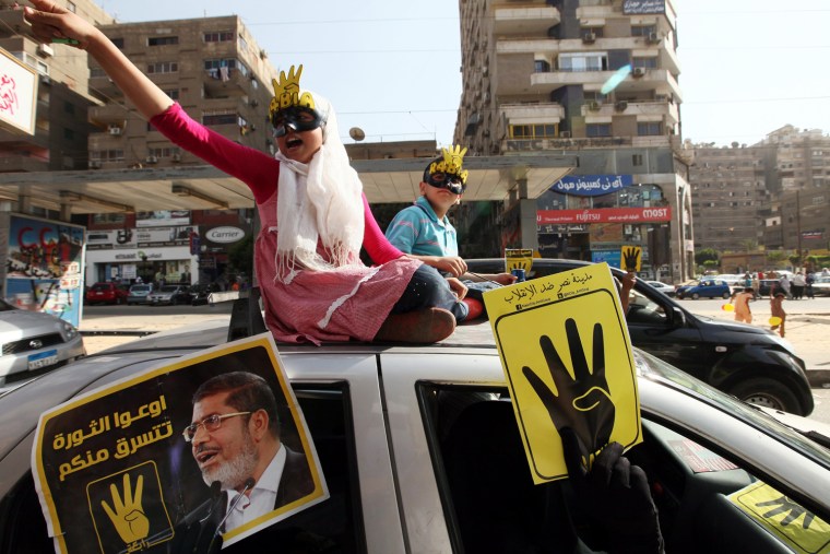 Egyptian supporters of ousted President Mohamed Morsi hold posters depicting Morsi and the 'four-fingered salute' during a protest in Cairo, Egypt last week.