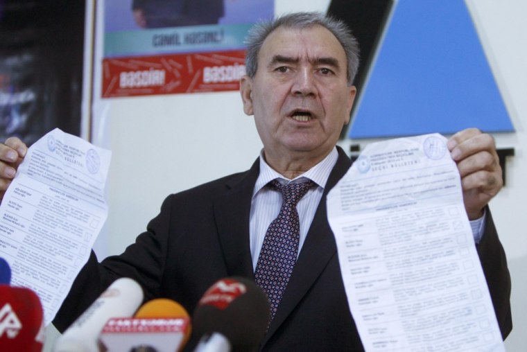 Opposition candidate Jamil Hasanli holds ballots as he speaks at a news conference in Baku on Thursday.