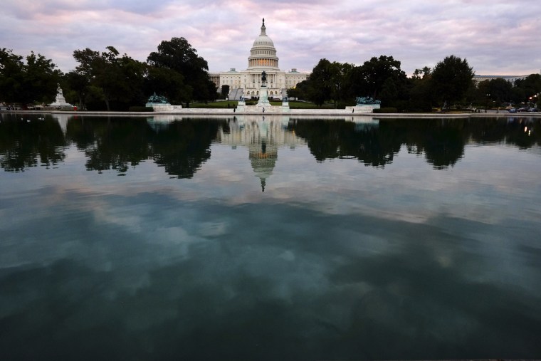The Capital is mirrored in the Capital Reflecting Pool on Capitol Hill in Washington early Tuesday, Oct. 1, 2013.