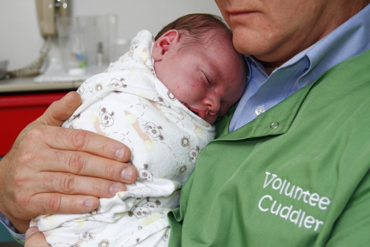 Baby Jason, 3 Â½ weeks, is held snugly by Chuck Morgan, a volunteer â€˜cuddlerâ€™ with East Tennessee Childrenâ€™s Hospital.