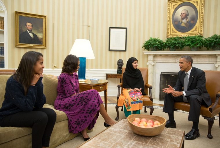 In this handout image provided by the White House, President Barack Obama, first lady Michelle Obama, and their daughter Malia Obama meet with Malala Yousafzai in the Oval Office, Oct. 11, 2013 in Washington, DC.