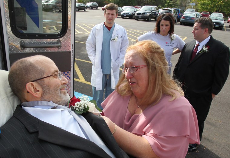 Scott Nagy's wife Jean pins the corsage to her husband's jacket before the start of their daughter's wedding ceremony at First Lutheran Church in Strongsville, Ohio, on Oct. 12. University Hospital sent a medical team along with Scott who is bound to his bed. The ambulance ride to the church was donated by Physicians Medical Transport.