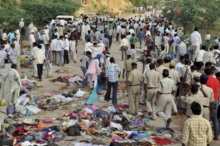 Indian villagers gather as policemen arrive at the scene of the deadly stampede in Madhya Pradesh, Sunday.